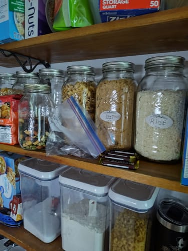 Reviewer's pantry showing mason jars of noodles, brown sugar, and rice sealed with the Mason Genie to keep food fresh.