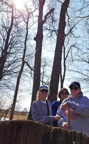 Customer wearing the gray Guadalupana hoodie outdoors with two friends.