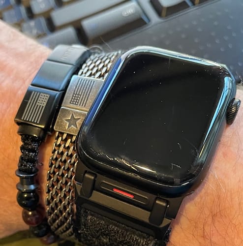 Customer's wrist showing two bracelets with American flag designs next to a watch.