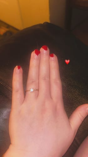 Customer's hand with red nails wearing the Sofia Crystal Twisted Ring.