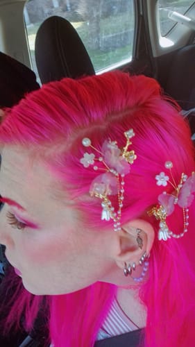 Reviewer from the side, showing the textured Manga - Brown lashes paired with vibrant pink makeup and hair.