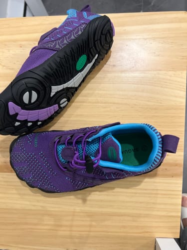 Customer's purple and teal Free I Barefoot Shoes on a wooden surface, showing the top and flexible sole.