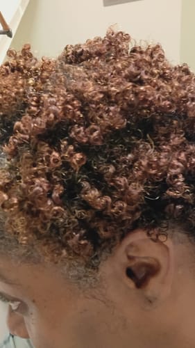 Close-up of a reviewer's defined, shiny curls after using Tropical Oasis Hair Gel.