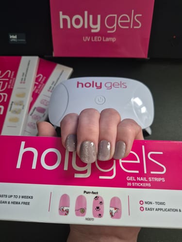 Reviewer's hand with a neutral-toned Holy Gels manicure, displayed with the starter kit box and UV lamp in the background.