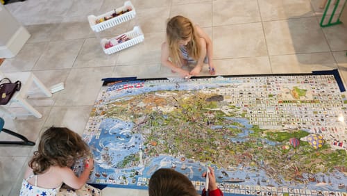 Customer's children on the floor interacting with the large, detailed USA Edition poster.