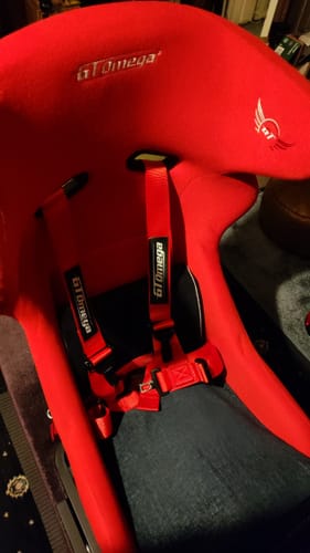 Customer's red 4-Point Racing Harness installed in a matching red sim racing seat.