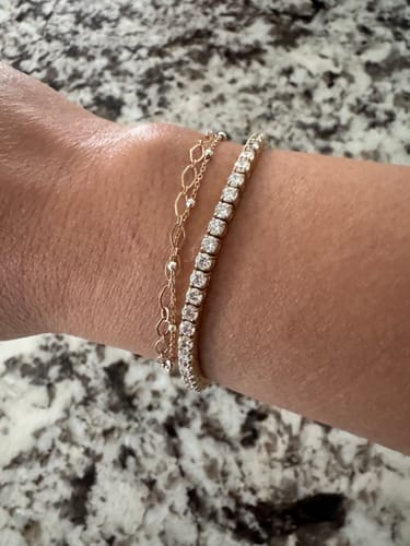 Reviewer wearing the sparkling Luxe Tennis Bracelet on their wrist, stacked with another delicate bracelet.