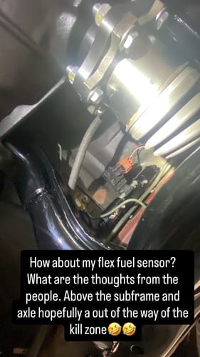 Customer's Billet E85 Flex Fuel Sensor Mount installed on a vehicle's undercarriage, above the subframe and axle.