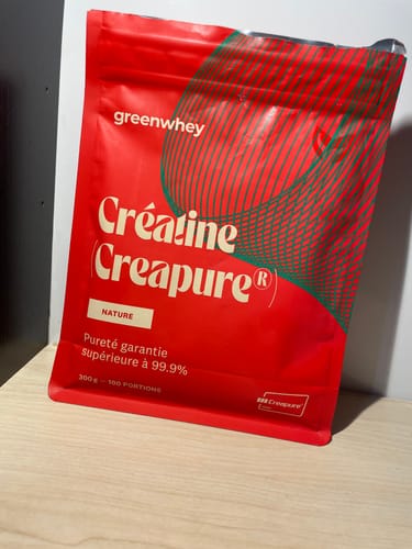 Photo d'un client montrant le sachet rouge de Créatine Creapure® posé sur une table.