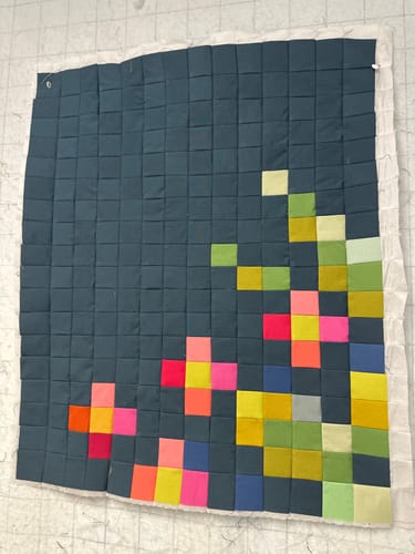 Customer's Tilda Embroidery Flower quilt panel in progress, with colorful pixelated shapes on a dark background.