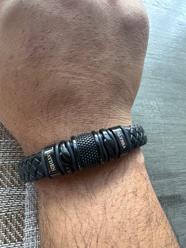Customer's black personalized bracelet on their wrist, showing the names Jayden and Alyssa.