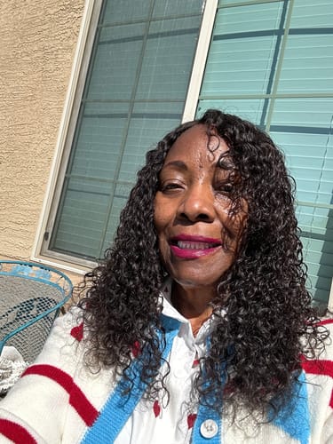 Customer outdoors smiling, showing her defined curly hair styled with the mousse.