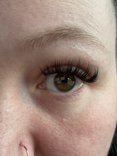 Nahaufnahme einer Kundin, die lange, dichte Wimpern aus der AYLASHES Mystery Box trägt.