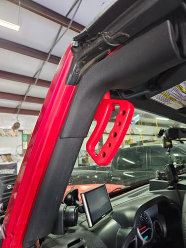 Customer's stout, red CMM Offroad Knuckle handle installed on the A-pillar of a Jeep.