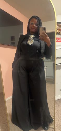 Reviewer in a mirror selfie wearing a black outfit with a cropped blazer and wide-leg pants.
