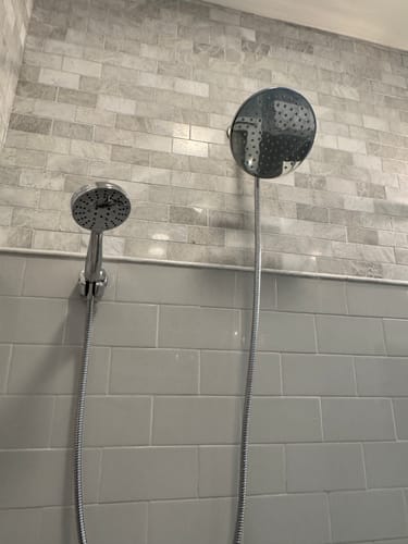 Reviewer's chrome Dual Shower Head Set with both the rain and handheld heads installed in a tiled shower.