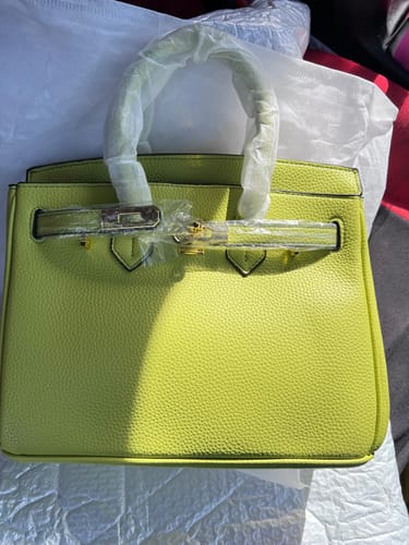Customer showing a new lime Warkin Bag with protective plastic on the handle and closure.