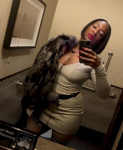 Reviewer's mirror selfie wearing the chic LEATHER ENERGY MINI DRESS with a furry coat over one shoulder.