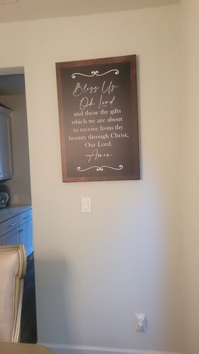 A reviewer's vertical faith sign with a prayer hanging on a dining room wall.