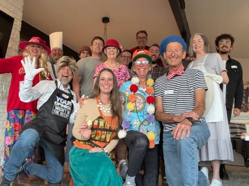 Customers in various fun costumes posing for a group photo while playing the Bake Off Murder Mystery Game Kit.