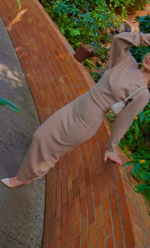 Reviewer posing in the beige Knit Off-Shoulder Sweater Maxi Dress against an outdoor brick wall.