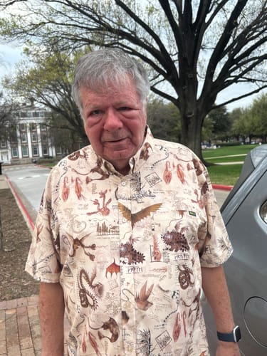 Reviewer wearing the patterned How to Train Your Dragon 'Book of Dragons' shirt outdoors.
