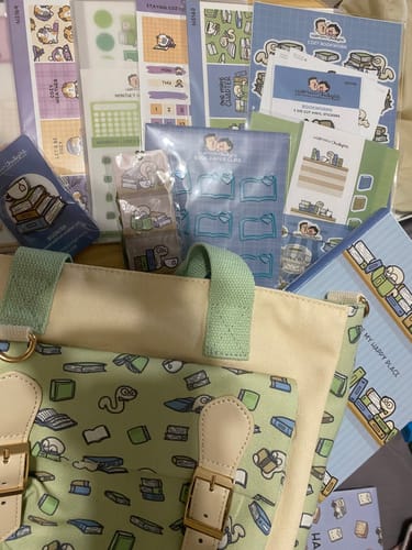 Reviewer's Cozy Bookworm Box Set spread out, showing the cute tote bag, sticker sheets, and other stationery items.