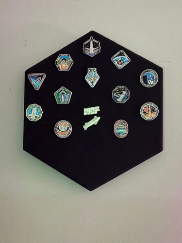 Customer's Starship Flight Pin Collection arranged on the black hexagonal display mount, hanging on a wall.