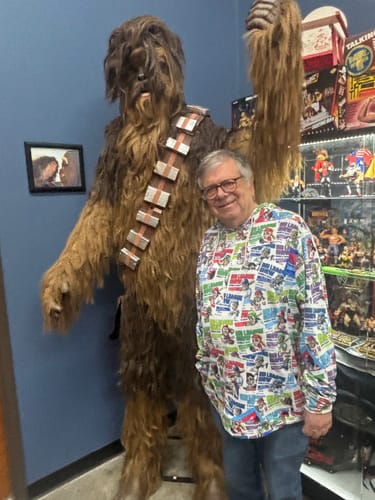Reviewer wearing the colorful Big League Chew hoodie while standing next to a life-sized Chewbacca figure.