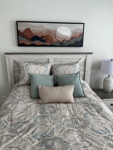 Reviewer's framed Abstract Mountains Landscape Wall Art Canvas hanging on a bedroom wall above a bed.