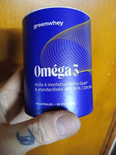 Main d'un client tenant le pot bleu des compléments Oméga 3 EPAX®.