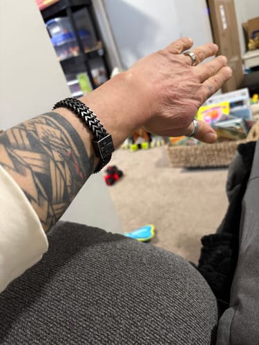 Customer wearing the Guardian’s Oath Cross Link Bracelet on their tattooed wrist.