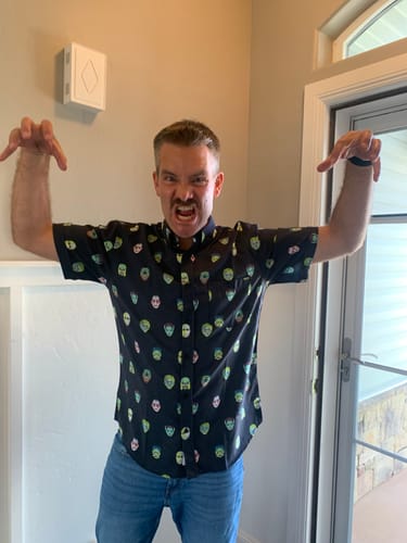 Reviewer making a monster pose while wearing the black Universal Monsters 'Fright Club' Short Sleeve Shirt.