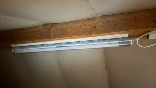 Kundenbild der ausgeschalteten LEDVANCE Feuchtraumleuchte, die an einem Holzbalken auf dem Dachboden montiert ist.