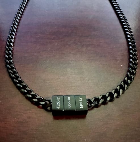 Customer's black Legacy necklace with three beads engraved with the names Jenny, Hannah, and Molly.