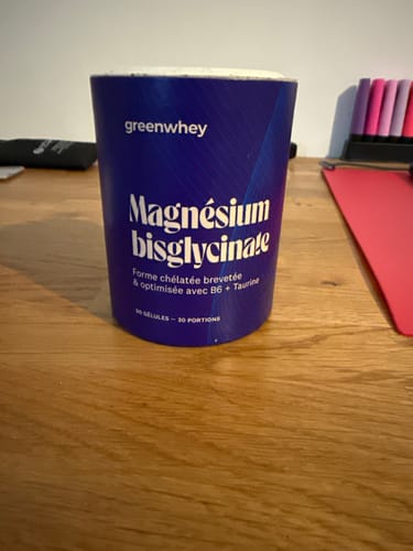 Photo d'un client du pot bleu de Magnésium Bisglycinate posé sur un bureau en bois.