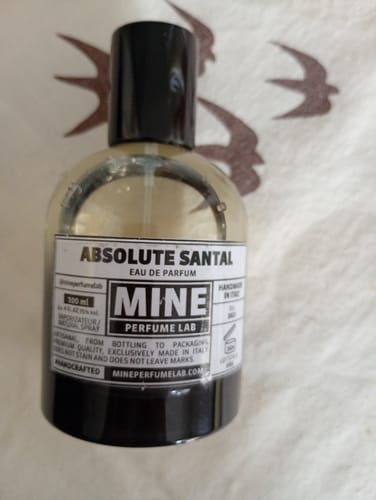 Cliente mostra il flacone trasparente del profumo Absolute Santal di Mine Perfume Lab.