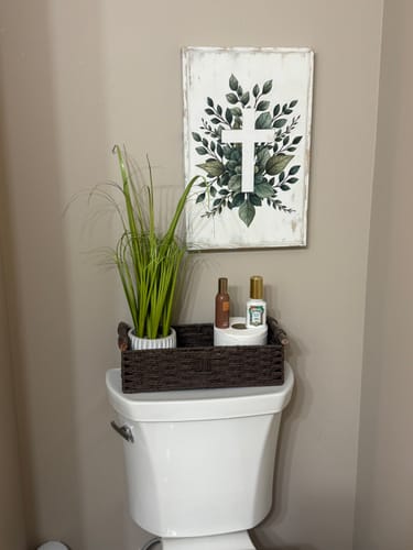 Customer's Minimalist Cross Faith Wall Art with green leaves and a white cross, hanging in a bathroom.