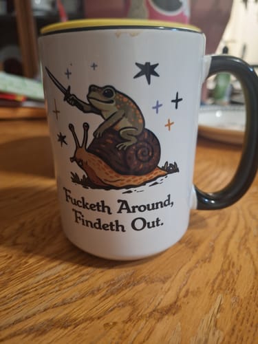 Customer's large white mug with a black handle, showing a frog on a snail and the text 'Fucketh Around, Findeth Out'.