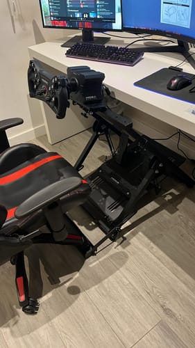 Customer's black APEX Wheel Stand with a racing wheel, showing the chair link attached to a gaming chair.