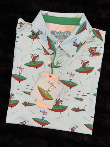 Customer's new Jetsons polo shirt, folded to show its light blue fabric and cartoon pattern of characters golfing in space.
