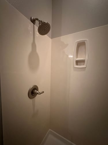 Customer's Gillian Filtered Shower Head installed in a white shower stall.