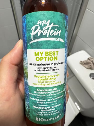 Recensent houdt de fles Bio Gentleaf Protein Leave In Conditioner in de hand.