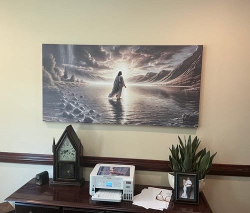 Reviewer's 'Walking on Water - Faith Wall Art II' canvas hanging on an office wall above a dark wood desk.