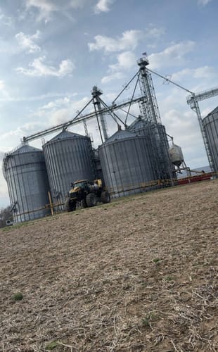 Customer's durable American flag flying atop a tall grain elevator on a farm.