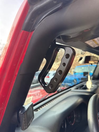Customer's black Front Loop Grab Handle installed on the passenger-side A-pillar of a red Jeep.