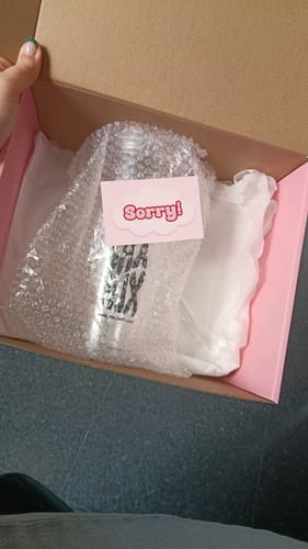 Cliente mostrando el empaque del Vaso Oficial de Matchaflix con el producto envuelto y una nota de disculpa.