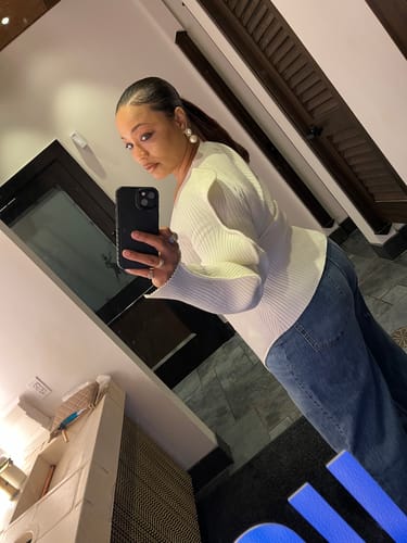 Reviewer taking a mirror selfie from the side, showing the fit of the white Wave Sleeve V-Neck Knitted Cardigan.