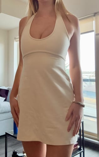 Customer showing the fit of the cream Halter Play Dress from the front.