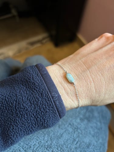 Cliente portant le bracelet Larimar fin avec sa pierre bleu clair au poignet.